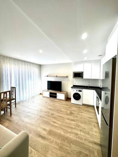 a large kitchen with white appliances and a living room at Apartamento La Muralla 2C in Aguilar de Campóo