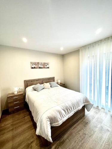 a bedroom with a large bed and a large window at Apartamento La Muralla 2C in Aguilar de Campóo