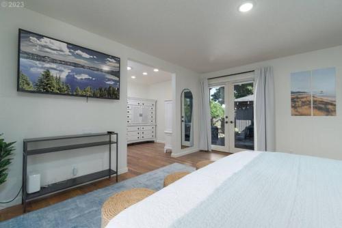 The Reunion Game House في يوجين: غرفة نوم بيضاء مع سرير كبير ومدفأة