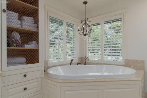a white bathroom with a tub and windows at The Reunion Game House in Eugene