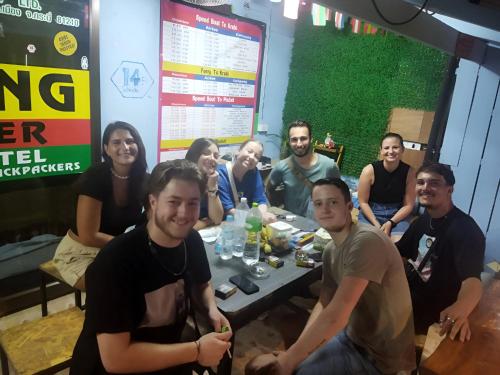 a group of people sitting around a table at Hangover Hostel in Phi Phi Islands