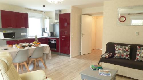 une cuisine et un salon avec une table et un canapé dans l'établissement Confortable appartement aux portes de Vannes, à Plescop