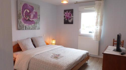 a bedroom with a bed and a window at Confortable appartement aux portes de Vannes in Plescop