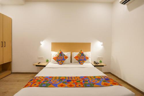 a bedroom with a large bed with colorful pillows at FabHotel Golden World in Ghaziabad