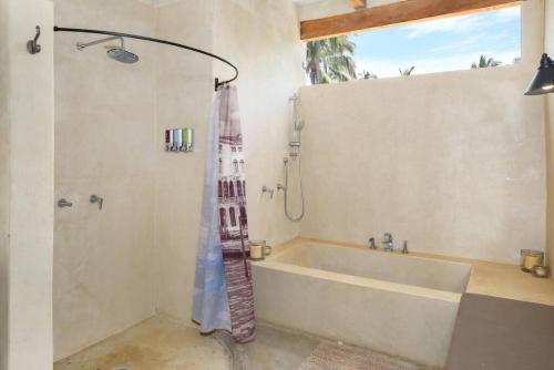 a bathroom with a tub and a shower with a tower at Entire Tocayo Steps to Beach and Surf 4BD Condo with Master Suite in Sayulita