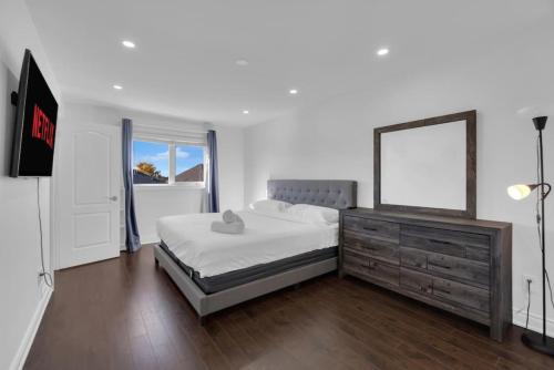a bedroom with a bed with a mirror and a dresser at Luxury 3BR - 10 Min to Wonderland - Monthly Rental in Vaughan