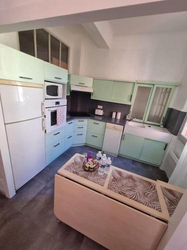 - une cuisine avec une table au milieu d'une pièce dans l'établissement Joli 2 pièces centre historique de Grasse, CLIM ET WIFI, à Grasse