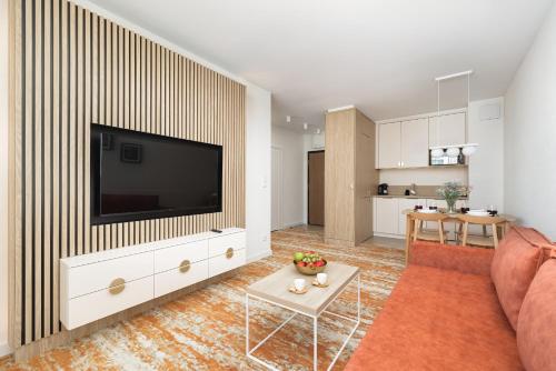uma sala de estar com uma televisão de ecrã plano na parede em Rent like home- Elegant Apartments with Balcony em Międzyzdroje