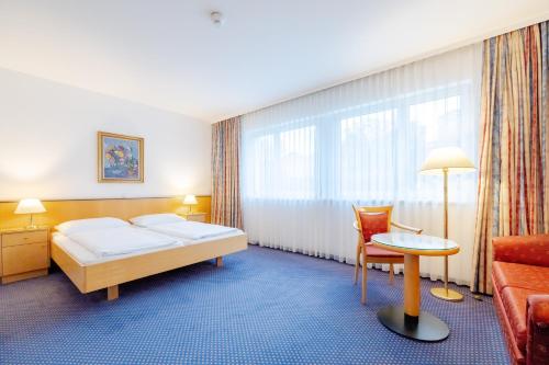 een hotelkamer met een bed en een bank bij Parkhotel Styria in Steyr