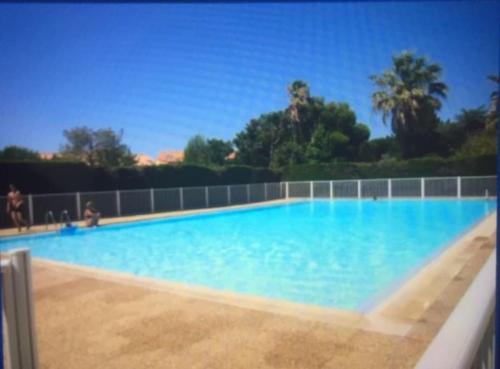 une grande piscine avec de l'eau bleue dans l'établissement STUDIO REFAIT À NEUF BORD DE MER, à Six-Fours-les-Plages