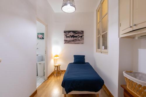 une chambre avec un lit avec une couverture bleue dans l'établissement La Comédie de Montpellier - Appt chaleureux, à Montpellier