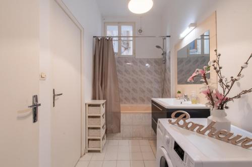 une salle de bain blanche avec un lavabo et une douche dans l'établissement La Comédie de Montpellier - Appt chaleureux, à Montpellier