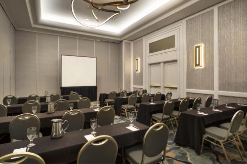 a conference room with tables and chairs and a screen at San Diego Marriott La Jolla in San Diego
