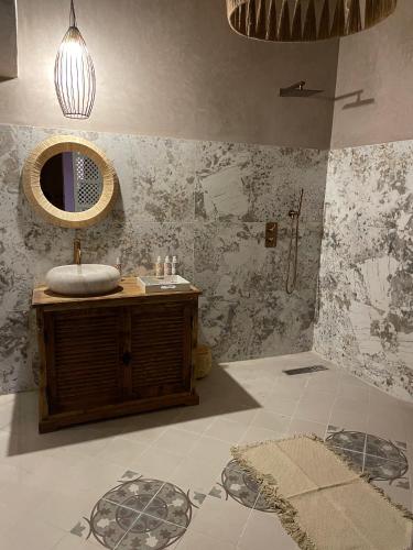 a bathroom with a sink and a mirror at Ksar Ighnda in Aït Ben Haddou