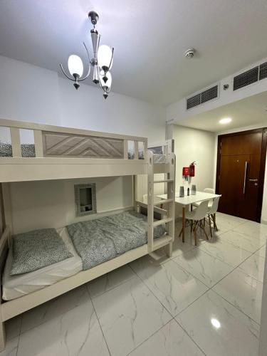 a bedroom with two bunk beds and a table at Homecation in Dubai