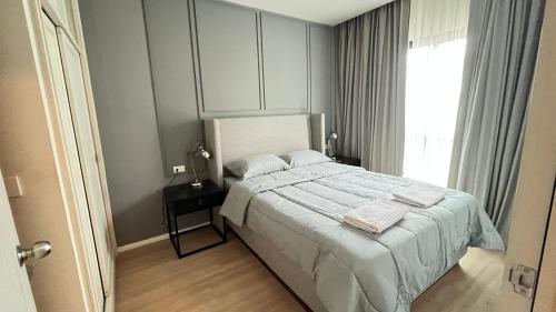 1 dormitorio con 1 cama con sábanas blancas y ventana en Chalong condo, en Ban Klang