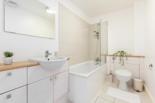 a white bathroom with a sink and a toilet at The Wembley Collection in London