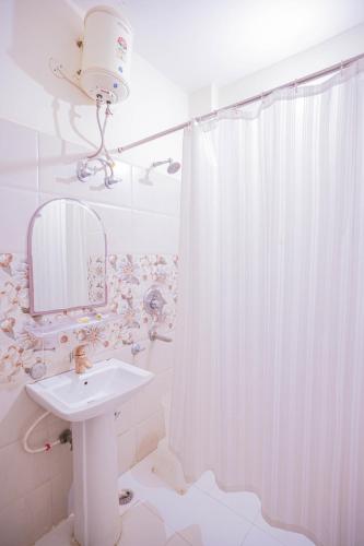 a bathroom with a sink and a shower curtain at Rajputana Heritage in Sawāi Mādhopur