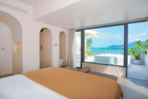 a bedroom with a bed and a view of the ocean at Shenzhen Semporna Beach Sea View B & B - 深圳较场尾仙本那沙滩海景民宿 in Shenzhen