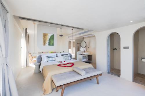 a white bedroom with a large bed and a bench at Shenzhen Semporna Beach Sea View B & B - 深圳较场尾仙本那沙滩海景民宿 in Shenzhen