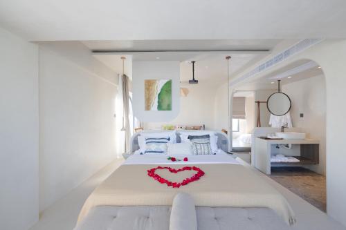 a bedroom with a white bed with a red heart on it at Shenzhen Semporna Beach Sea View B & B - 深圳较场尾仙本那沙滩海景民宿 in Shenzhen