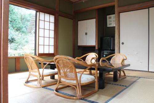 a dining room with a table and wicker chairs at HOTEL LT Kitchen Yugawara in Yugawara
