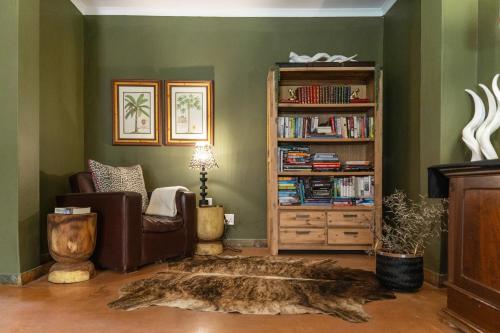 uma sala de estar com um sofá e uma estante de livros em Last Word Madikwe em Madikwe Game Reserve