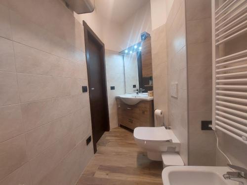 y baño con aseo blanco y lavamanos. en MGH Family Apartment Aprica - Gran Paradis en Aprica