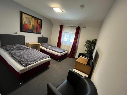 ein Zimmer mit 2 Betten und einem Stuhl darin in der Unterkunft Hotel Algar in Opava