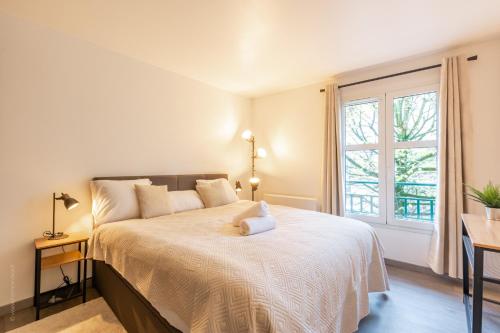 une chambre avec un grand lit avec une fenêtre dans l'établissement L'Explorateur by Plaza - Proche Disneyland Paris, à Chessy