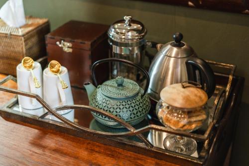 a tray with a tea kettle and other items on a table at Last Word Madikwe in Madikwe Game Reserve