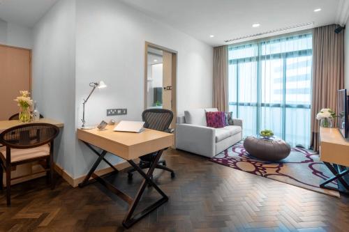 a living room with a desk and a couch at Fraser Suites Singapore in Singapore