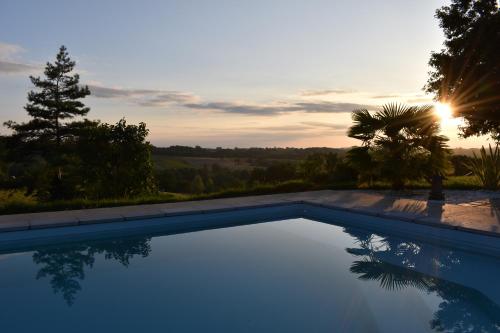 - une piscine avec vue sur le coucher du soleil en arrière-plan dans l'établissement Maison A Vallon, à Couloumé-Mondébat