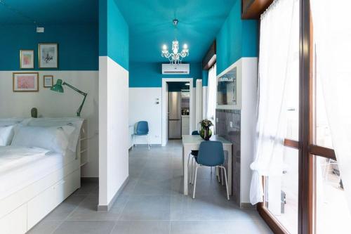 um quarto com uma cama, uma mesa e uma parede azul em CASA FIUMICELLO - VERONETTA em Verona