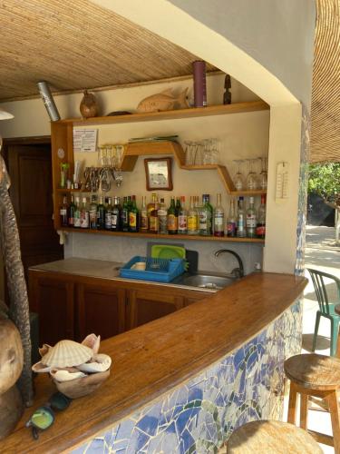 a kitchen with a counter with a sink and shelves at Keur des pecheurs chez ivan in Ouoran