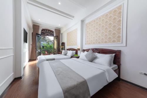 a bedroom with two beds and a painting on the wall at La Lisa Hotel in Hanoi