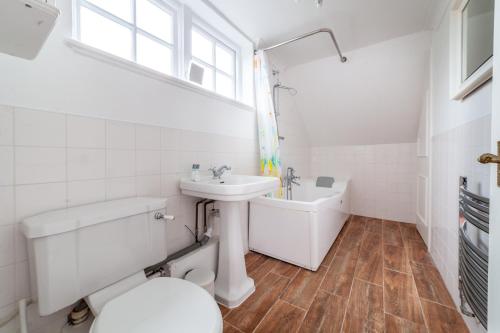 bagno bianco con lavandino e servizi igienici di The Lewisham Flats a Londra