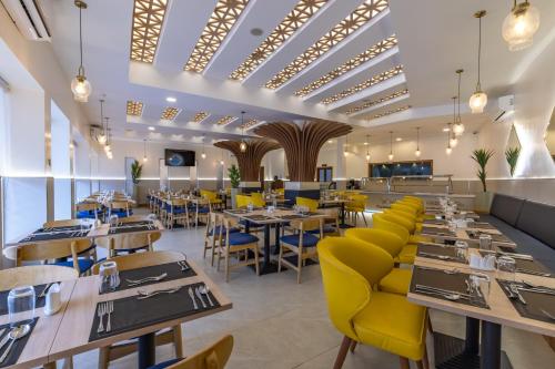 a dining room with tables and yellow chairs at Premium Inn Mombasa City in Mombasa