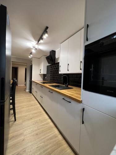 a kitchen with white cabinets and a black microwave at WOW HOME in Warsaw