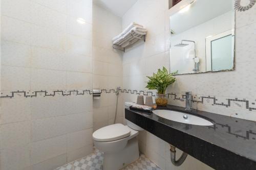 y baño con aseo y lavamanos. en La Lisa Hotel, en Hanói