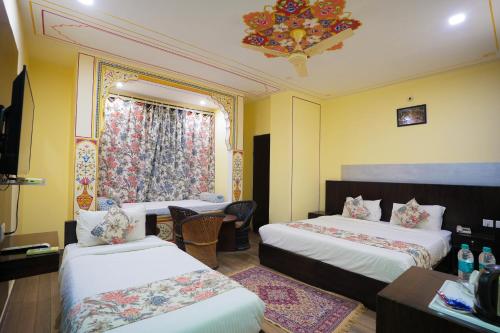 um quarto de hotel com duas camas e uma janela em Rajputana Heritage em Sawai Madhopur