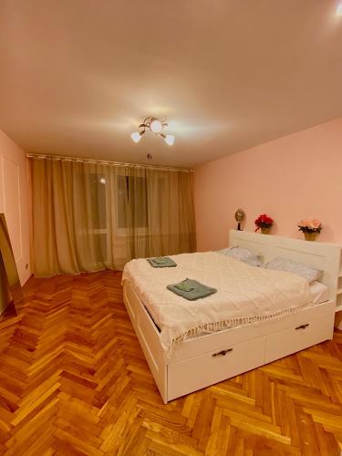 1 dormitorio con cama blanca y suelo de madera en Cheap entire apartment in a super location en Cracovia