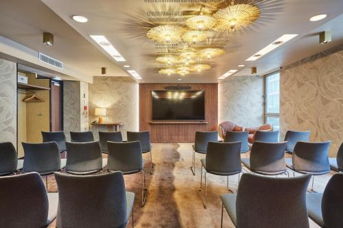 a conference room with chairs and a projection screen at voco Paris - Porte de Clichy by IHG in Clichy