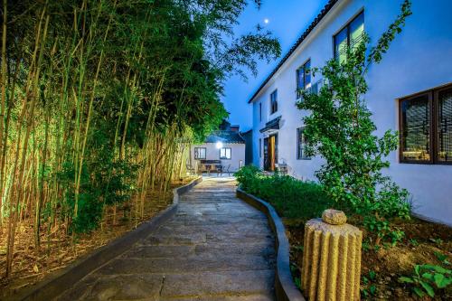 a stone path in front of a white building at Tongli Lanshe Garden B&B in Suzhou