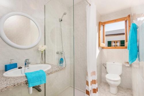 uma casa de banho com um WC, um lavatório e um espelho. em Villa Papaya by Villa Plus em Cala en Blanes