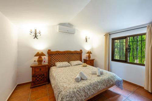 1 dormitorio con cama y ventana en Villa Paraiso Dos by Villa Plus, en Frigiliana