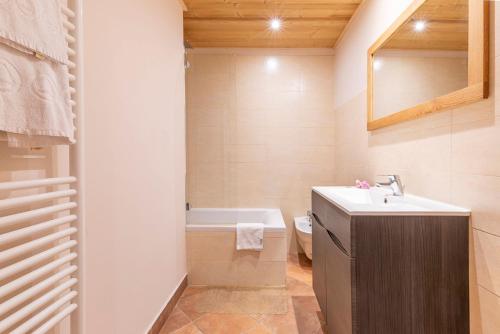 a bathroom with a sink and a bath tub at Résidence Les Arcades du Mont-Blanc in Megève