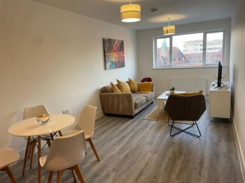a living room with a couch and a table and chairs at Beautiful Flat In Woking Central in Woking