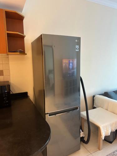 a stainless steel refrigerator in a kitchen with a table at sharja p702 in Sharjah