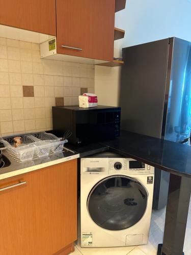 a kitchen with a washing machine and a black counter top at sharja p702 in Sharjah